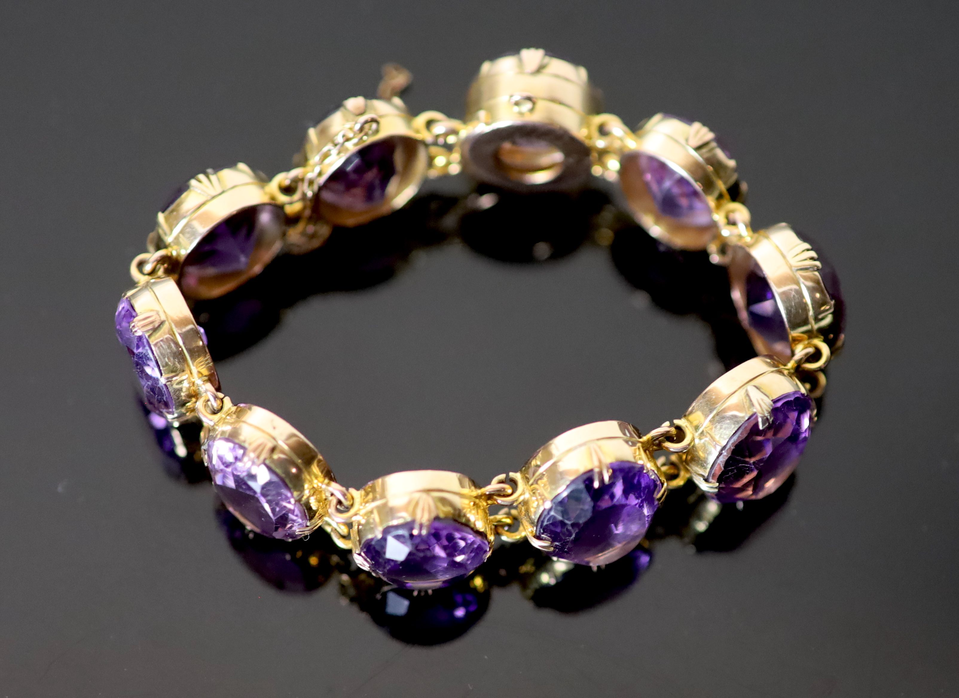 A Victorian style gold and ten stone oval cut amethyst set bracelet,